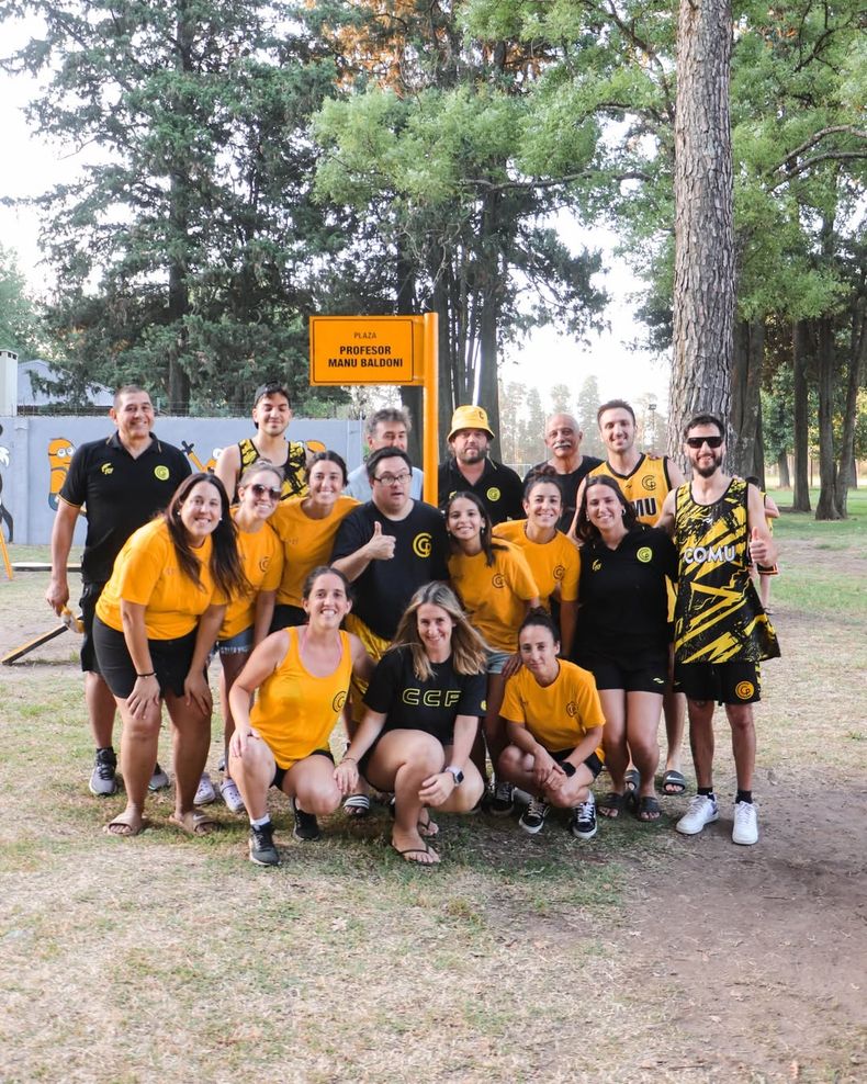 El grupo de trabajo de la Colonia de Verano del Club Comunicaciones junto a Manu Baldoni y el cartel de la plaza de juegos infantiles.